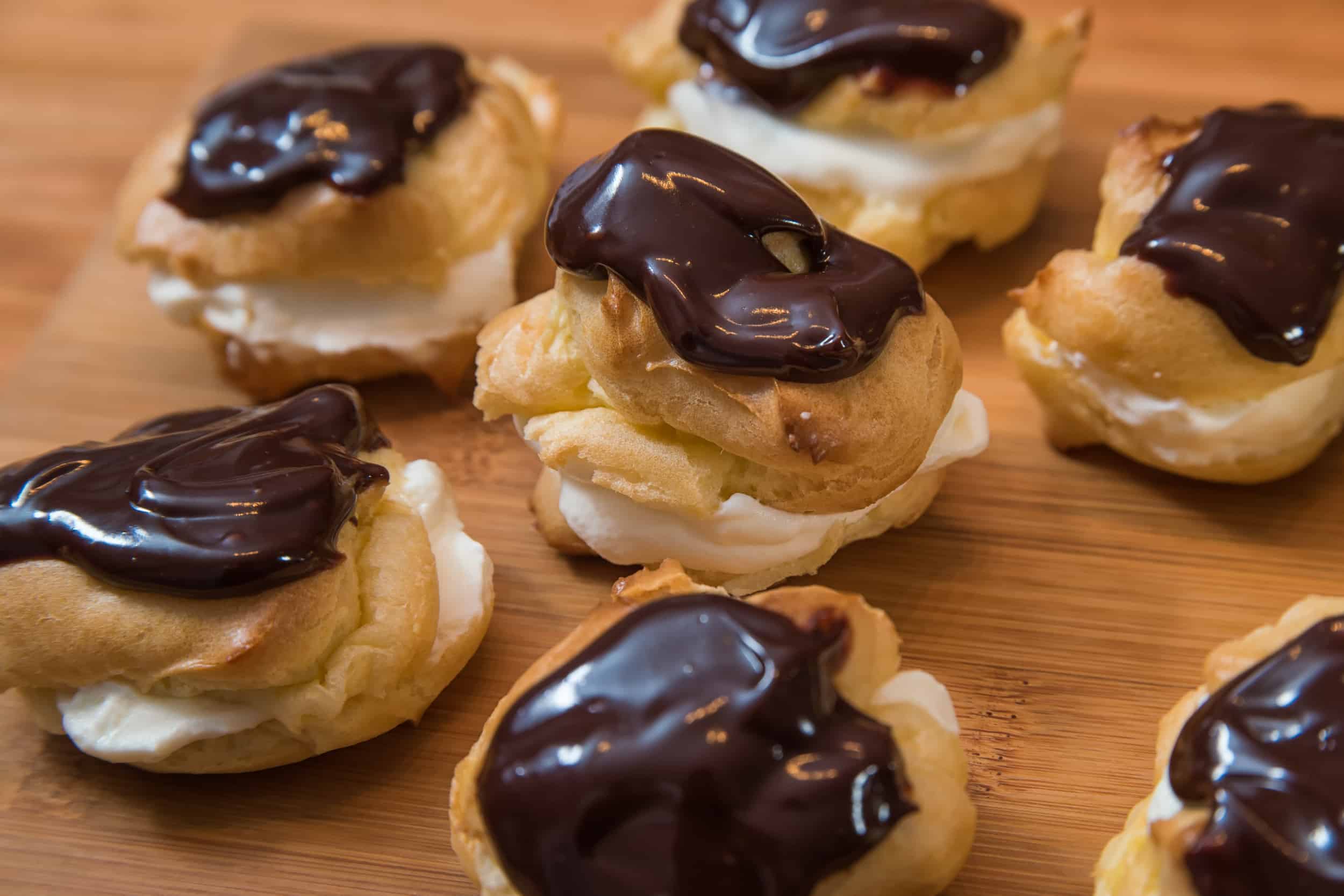 Fertiggebackene Windbeutel mit Schlagrahm und Schokoladen-Ganache